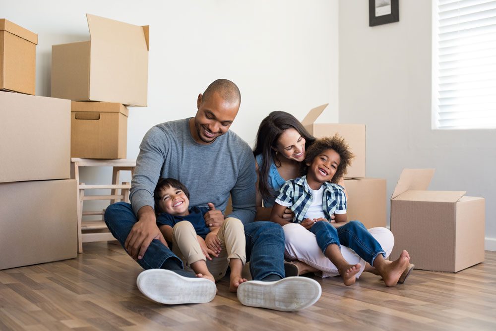 Family smiling in new home with boxes.