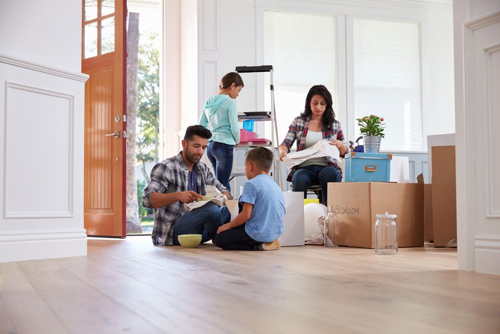 Family unpacking boxes in new home.