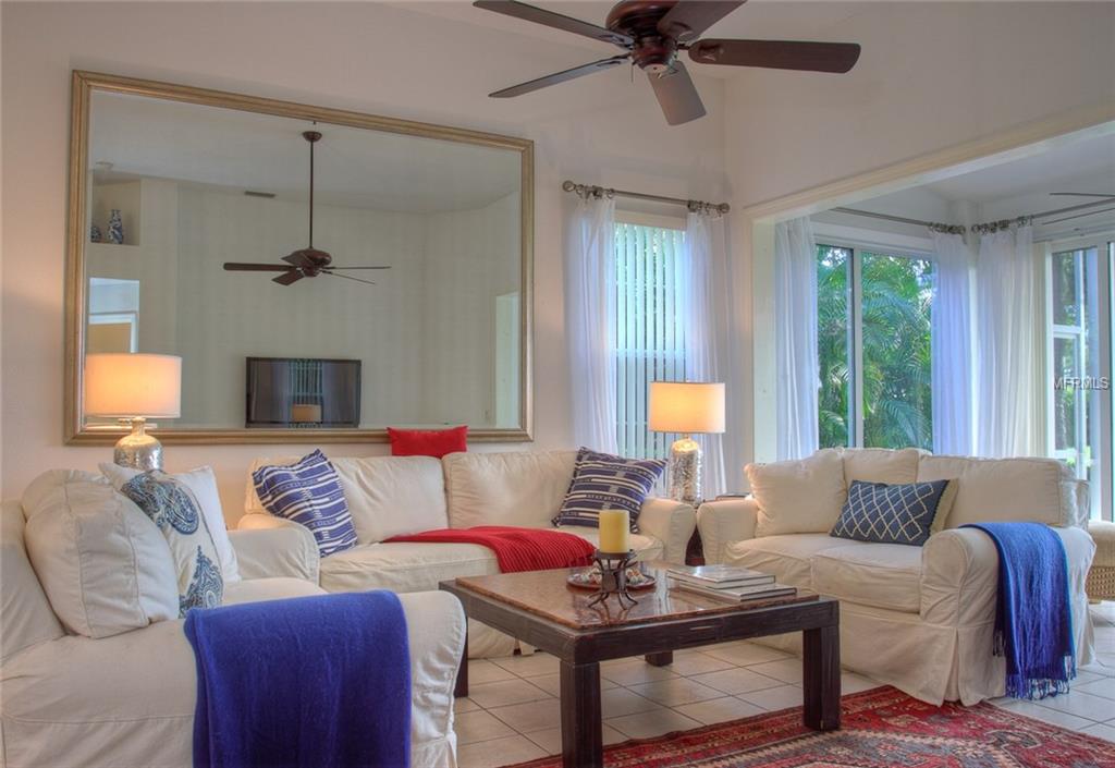 Living room with white couches and blue accents.