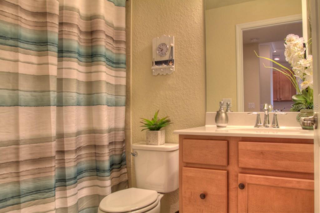 Bathroom with striped shower curtain and vanity