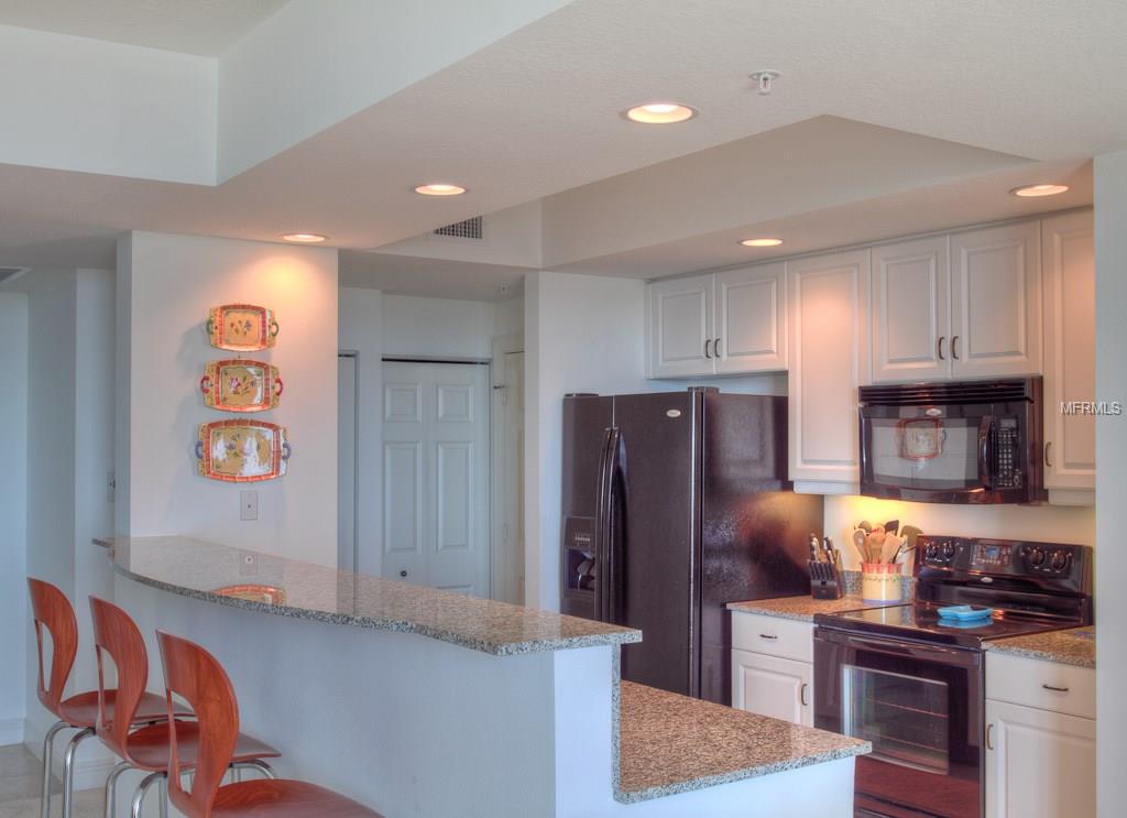 Kitchen with granite countertop and white cabinets.