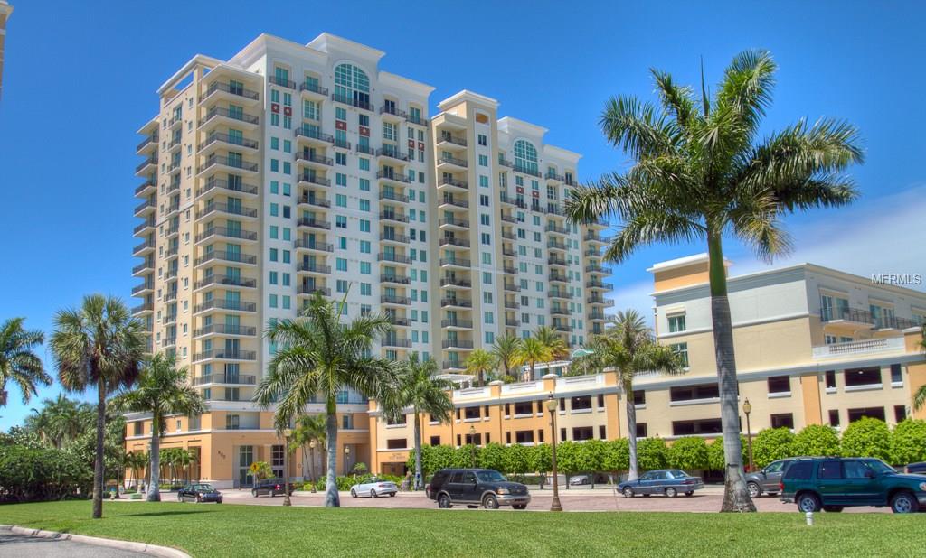 A tall apartment building with palm trees.