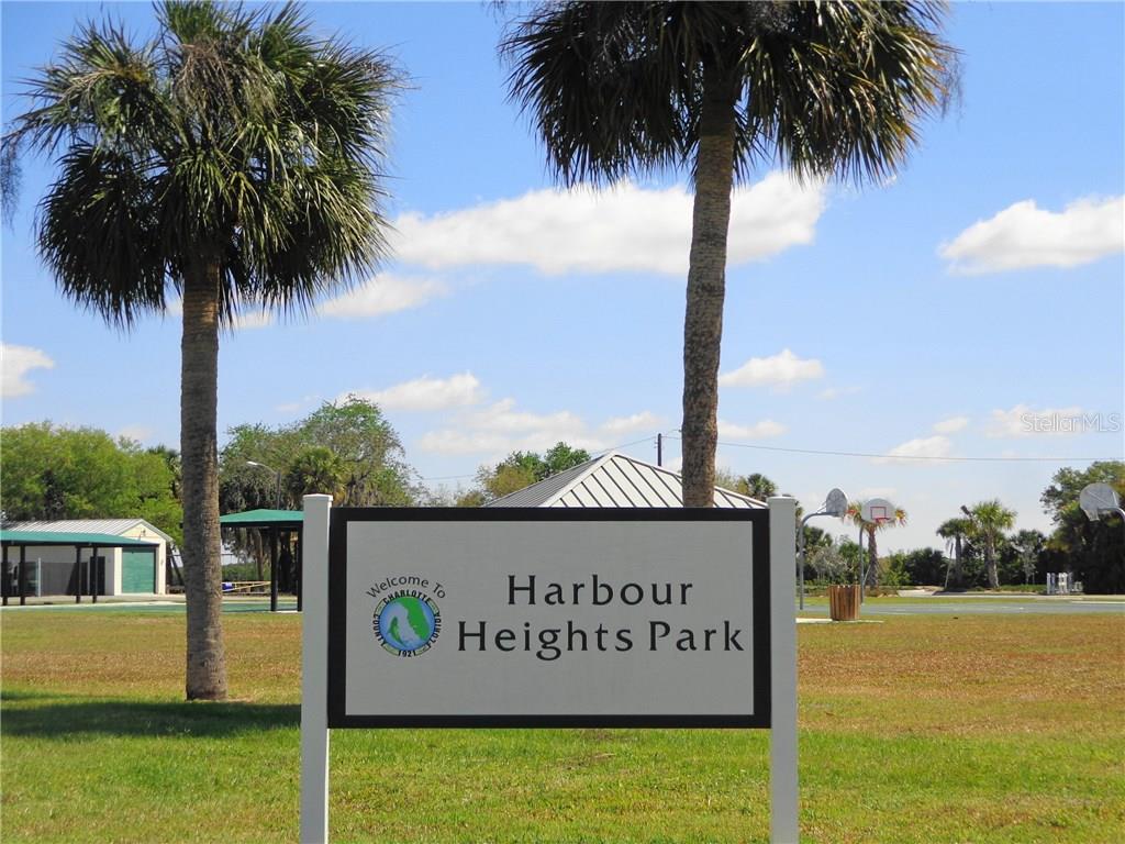 Sign for Harbour Heights Park with palm trees.