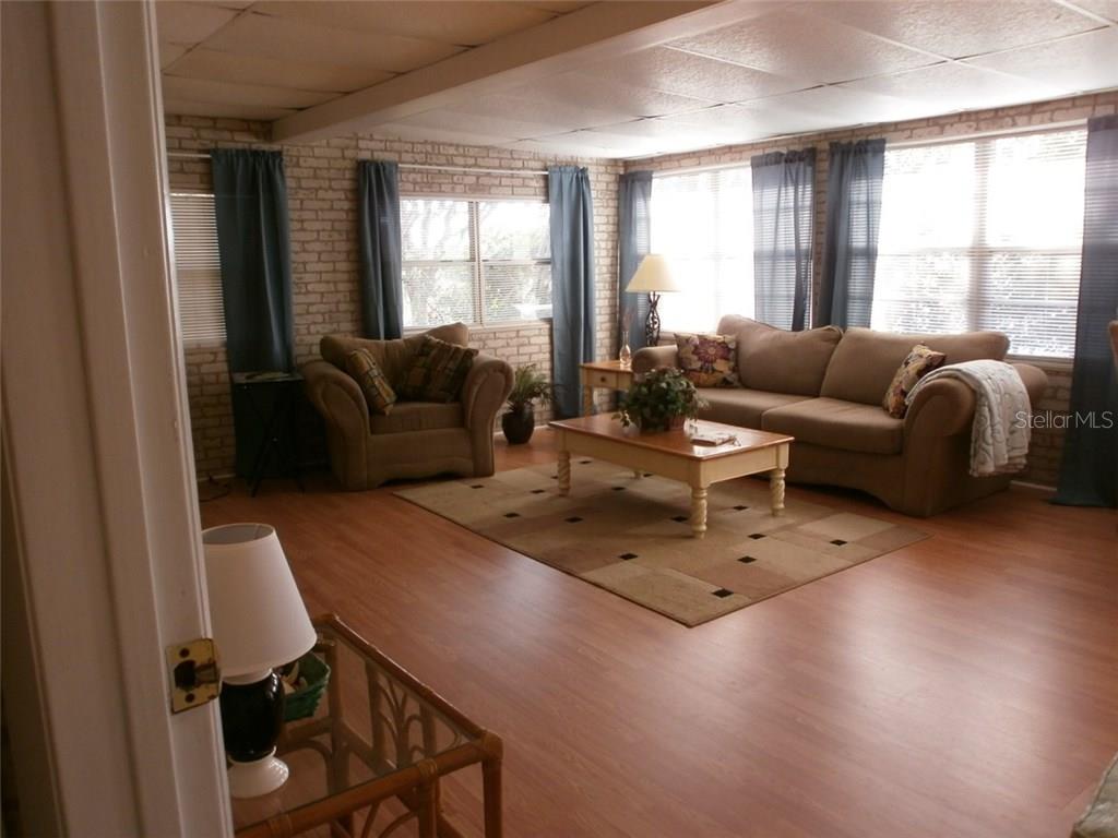 Living room with couch, rug, and windows.