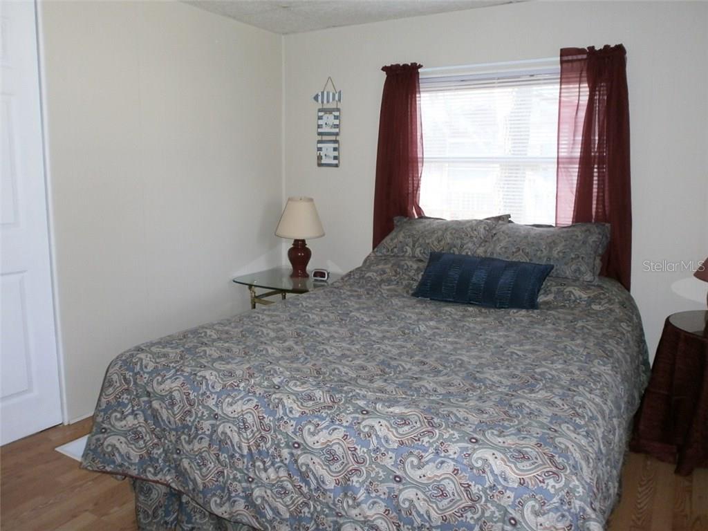 Bedroom with a bed, lamp, and window.