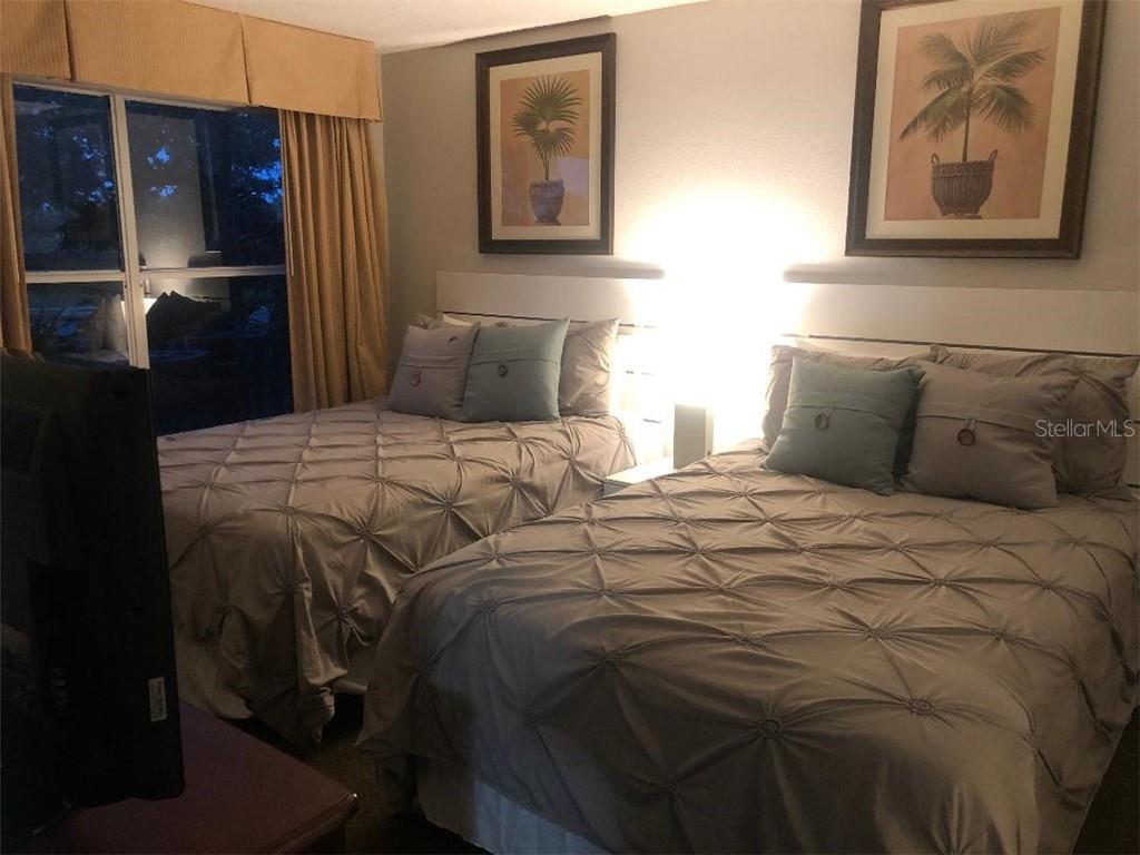 Two beds with patterned bedding in a bedroom.