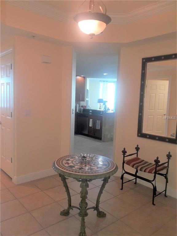 Entryway with tiled floor, table and bench.