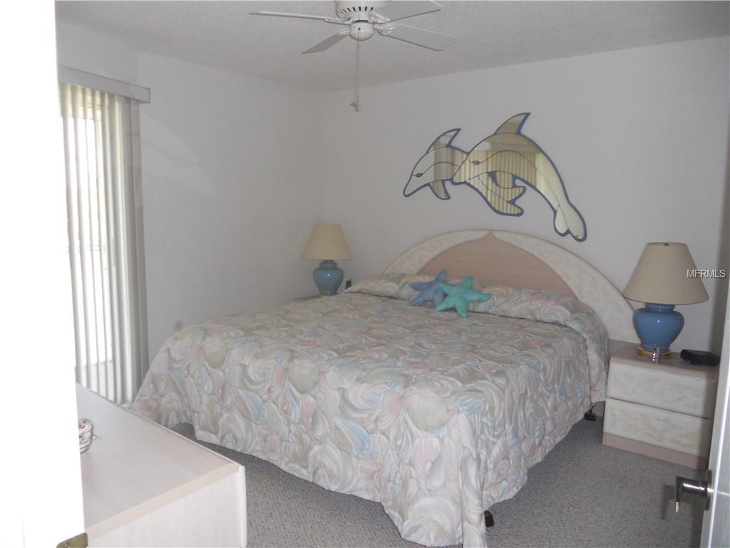 Bedroom with bed, dolphin mirror, and lamps.