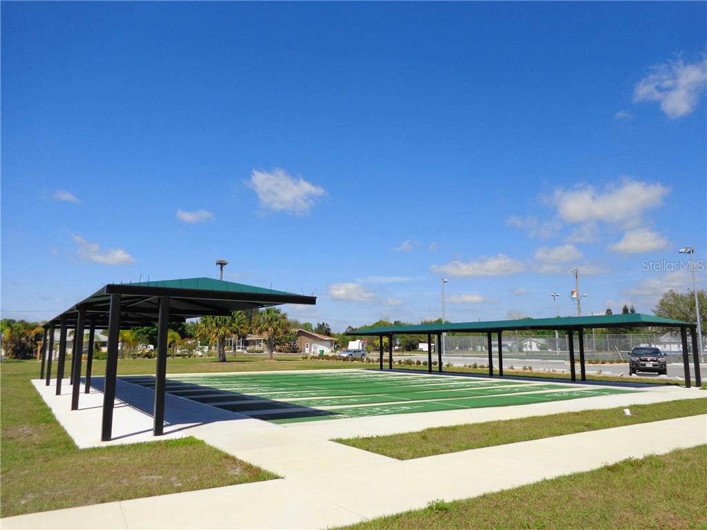 Covered outdoor game area with green turf.