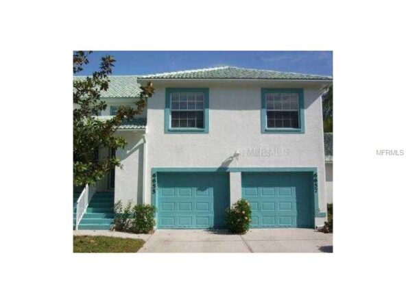 White house with teal garage doors