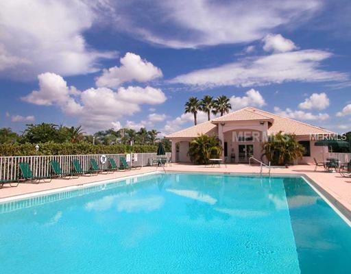 Swimming pool with a building and palm trees.