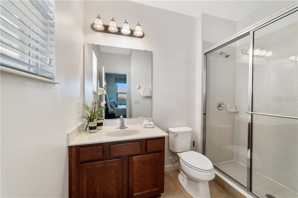 Bathroom with white sink and shower stall.