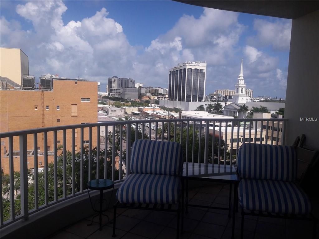 City view balcony with two chairs and a table.