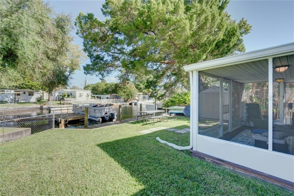 Backyard patio with screened porch and waterfront.