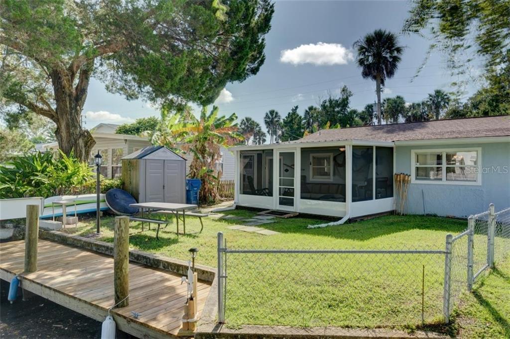 Backyard with a screened porch and dock.