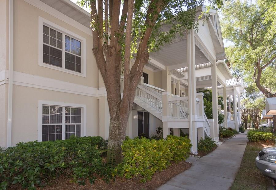 White building with covered porch and stairs.