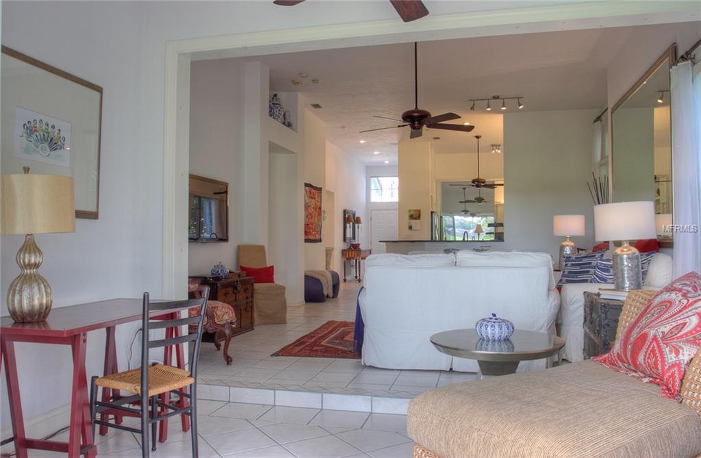 Living room with white couches and a table.