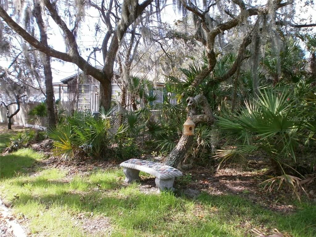 A stone bench in a grassy yard.