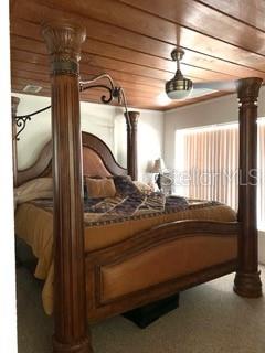 A large wooden canopy bed with bedding.