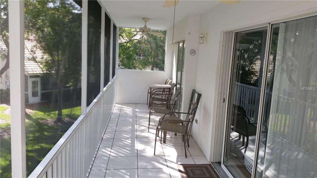 White porch with chairs and glass doors.