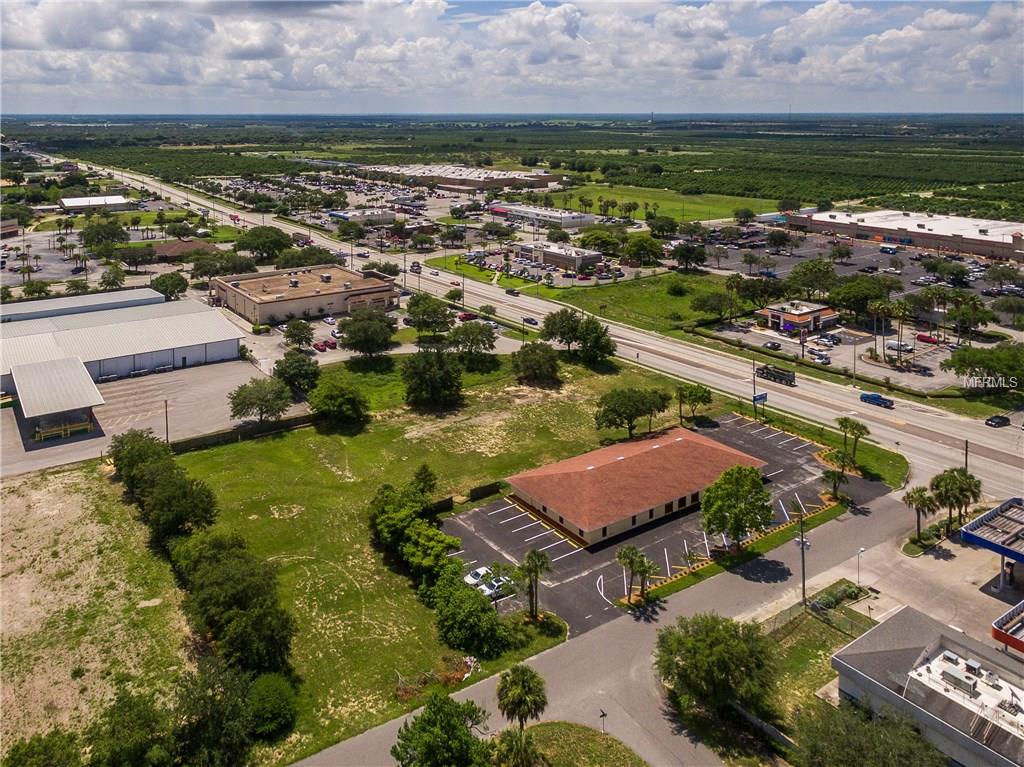 Aerial view of a vacant lot near businesses.