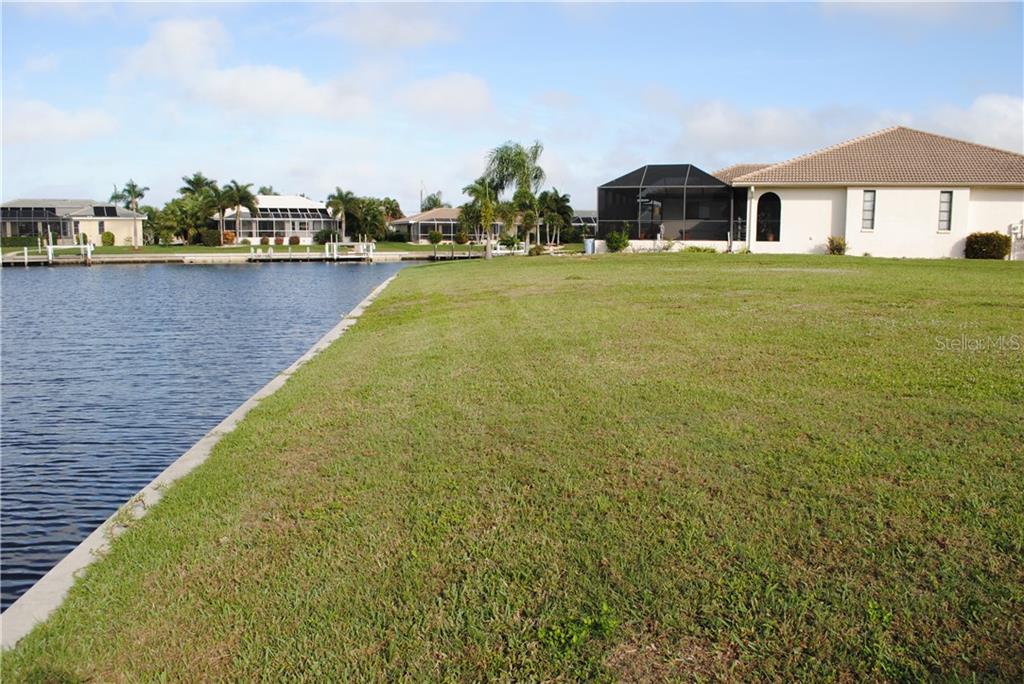 Waterfront lot with houses in the background.