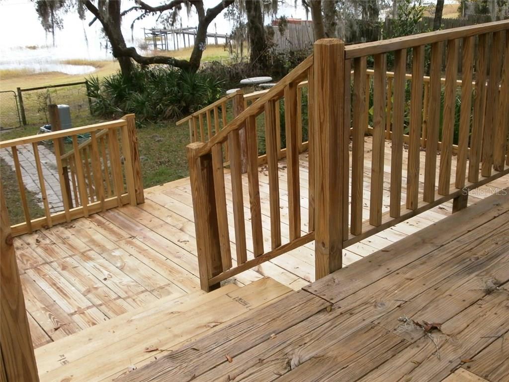 Wooden deck with railing and steps.