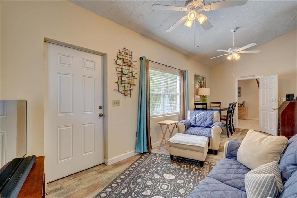 Living room with couch and ceiling fans.