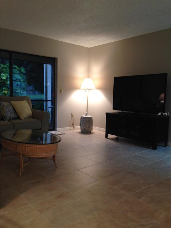 Living room with tiled floor and TV.