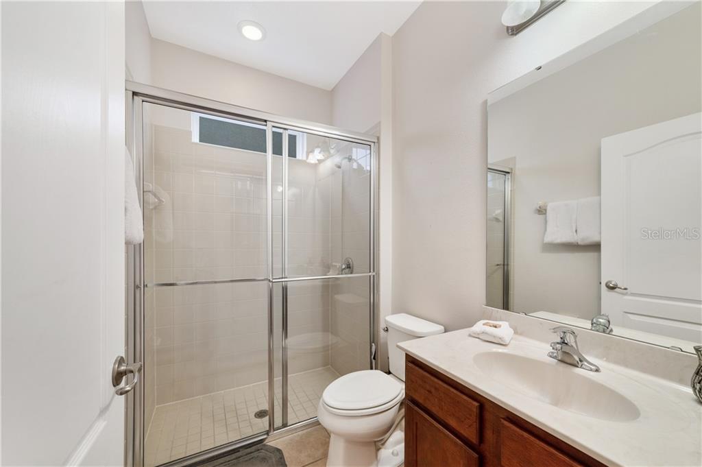 Bathroom with shower, toilet, and sink.