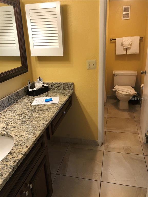 Bathroom with granite vanity and toilet.