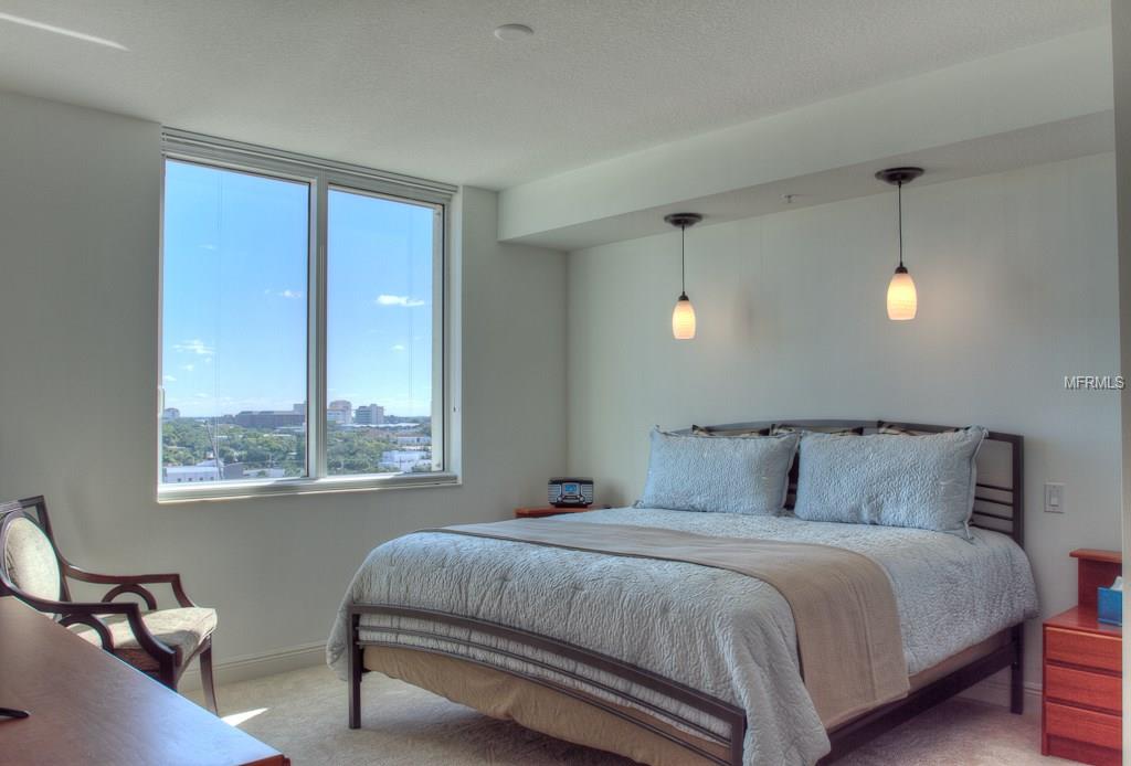 A bedroom with a view and a bed.