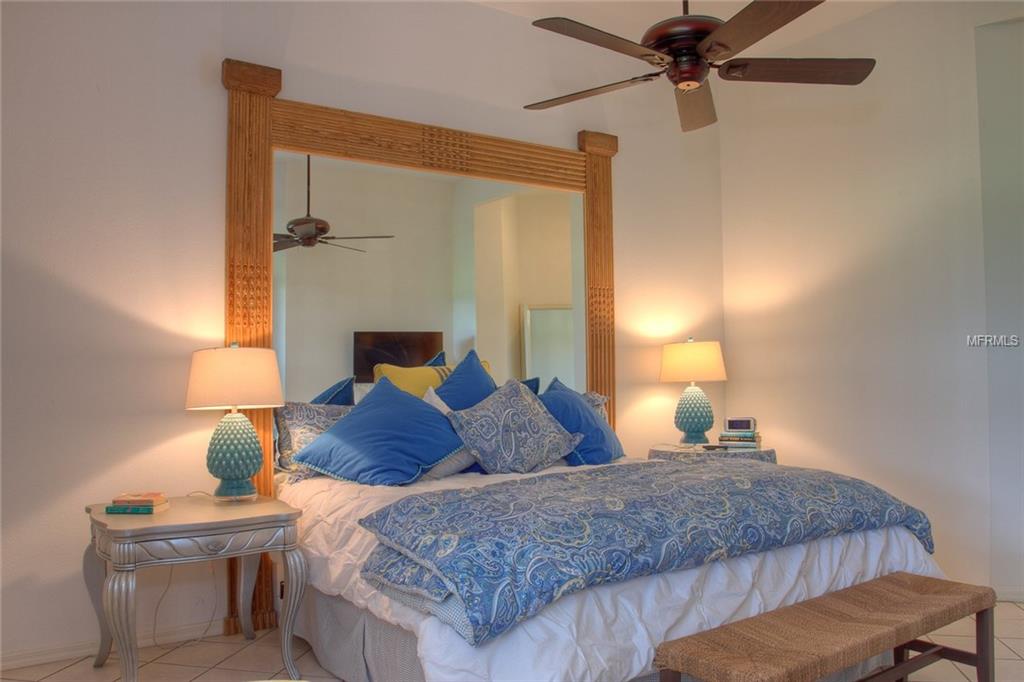 Bedroom with blue bedding and a large mirror.