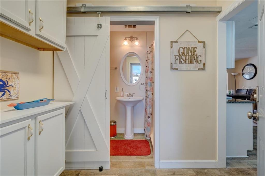 White bathroom with a "Gone Fishing" sign.