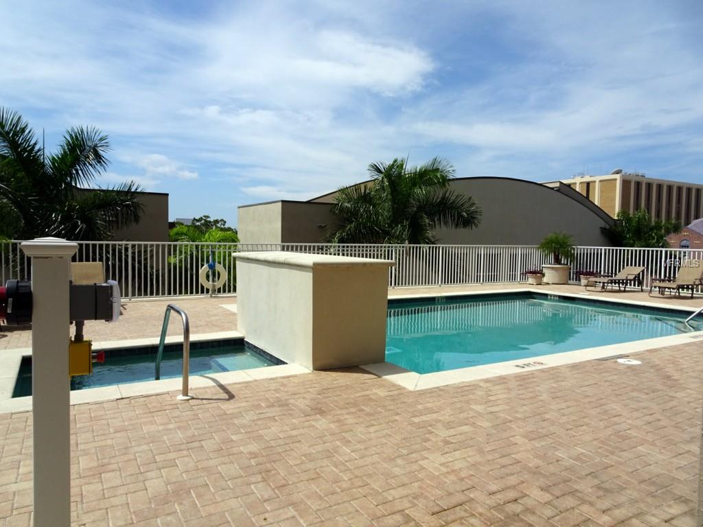 A rooftop pool with a brick patio.