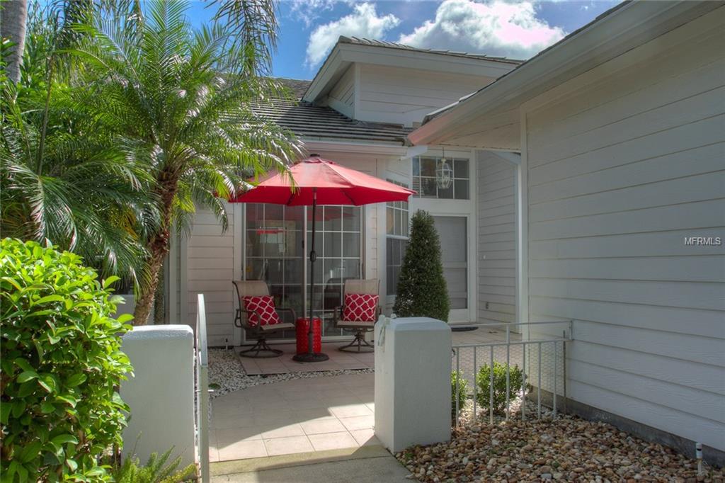 White house with red umbrella patio.