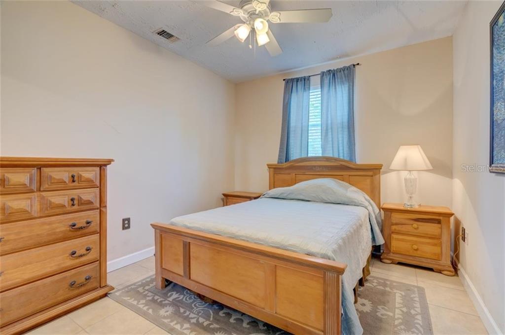 Bedroom with wooden bed, dresser, and nightstand.