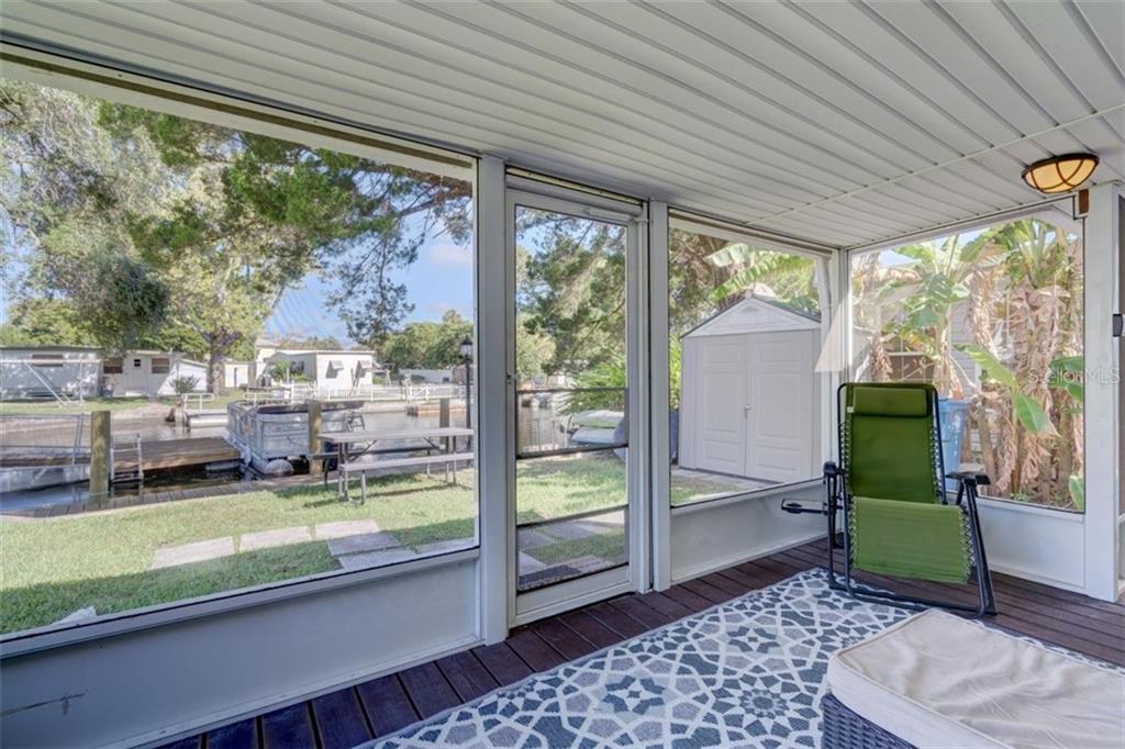 Screened porch with view of a canal.