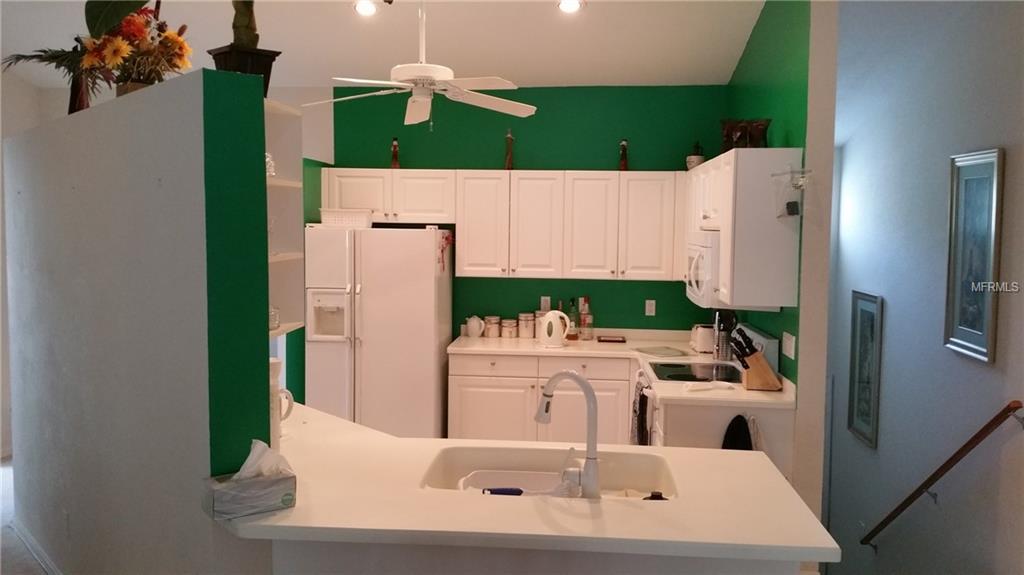 White kitchen with green walls and island.