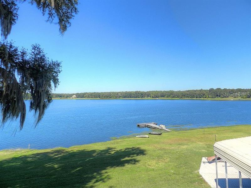 Lake view with grassy shore and dock.