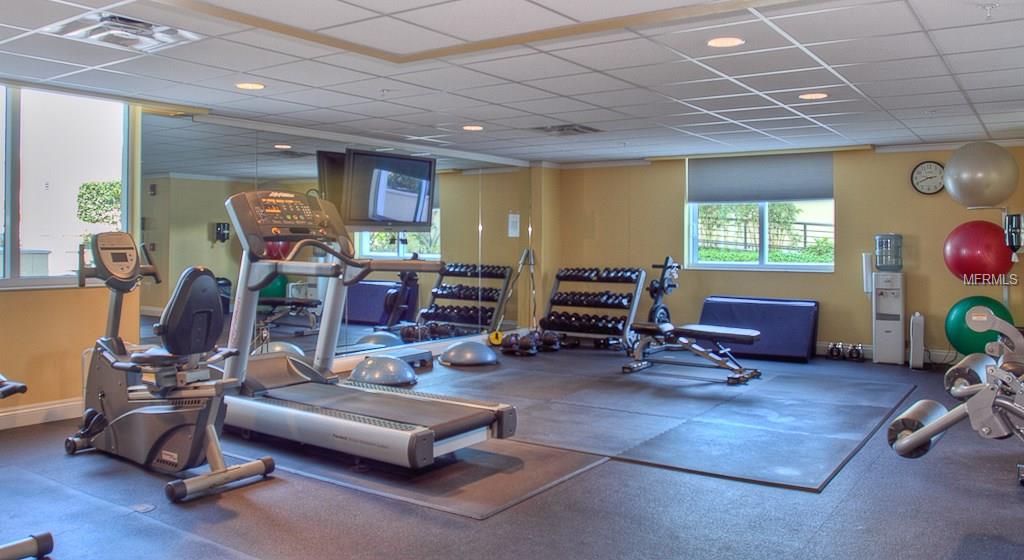 Fitness center with gym equipment and weights.