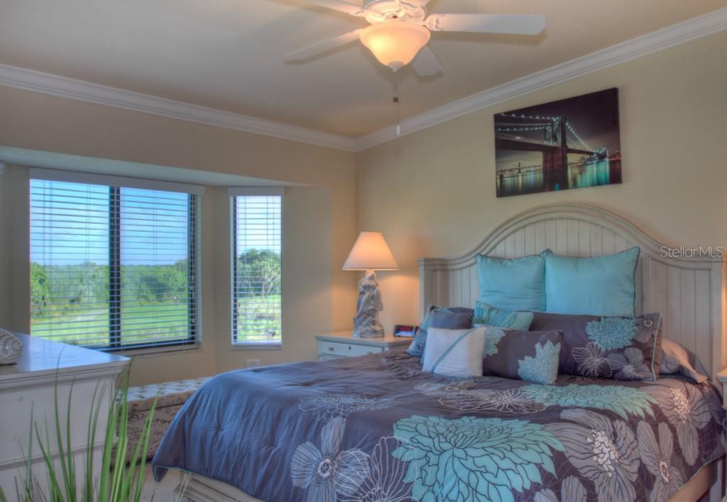 Bedroom with a bed, blue pillows, and a window view.