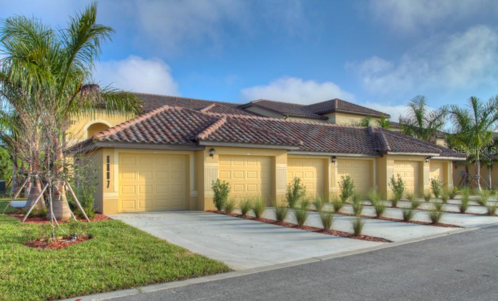 Exterior of a yellow house with garages.