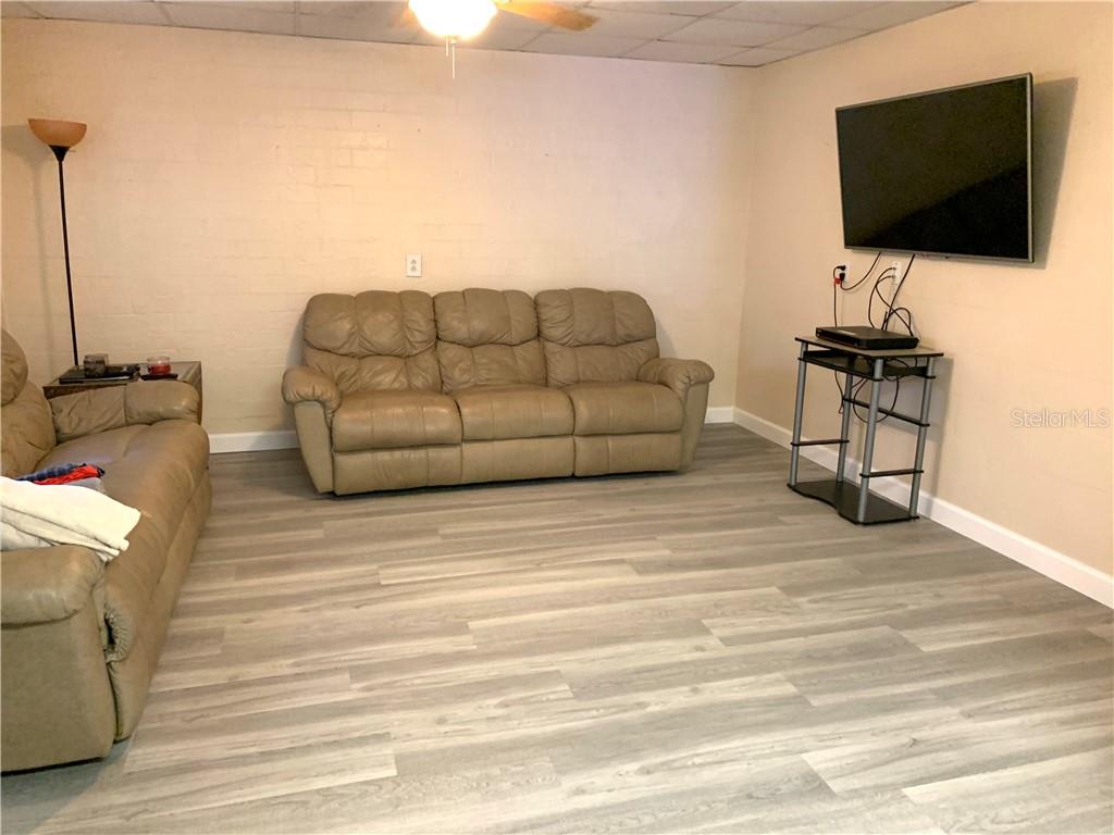 Living room with couch, TV, and wood floor.