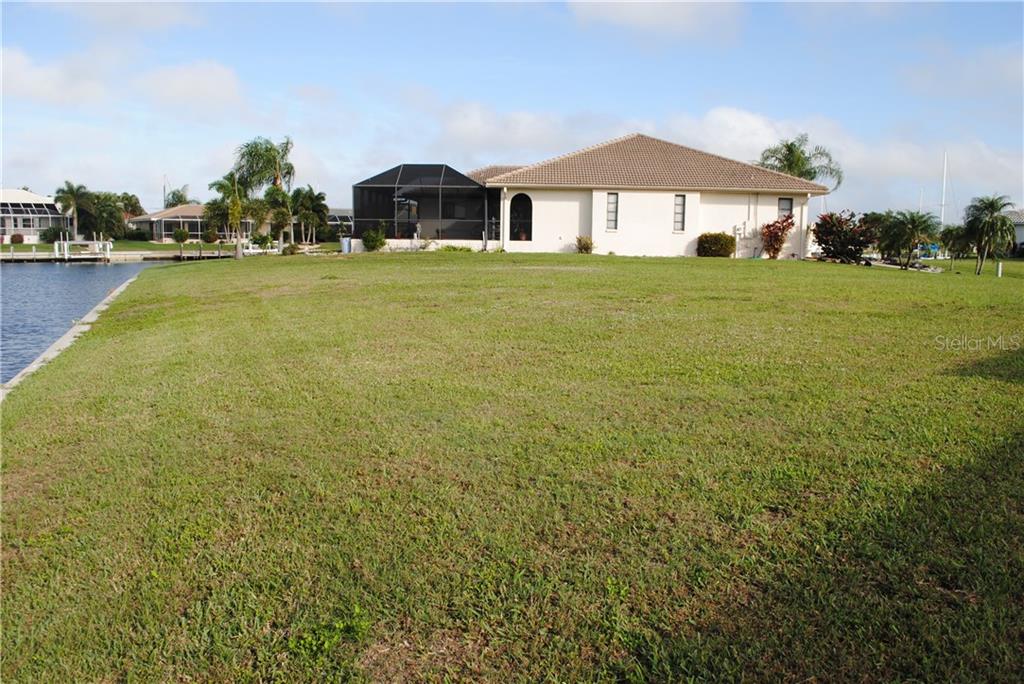 Green grass lawn with house in background.