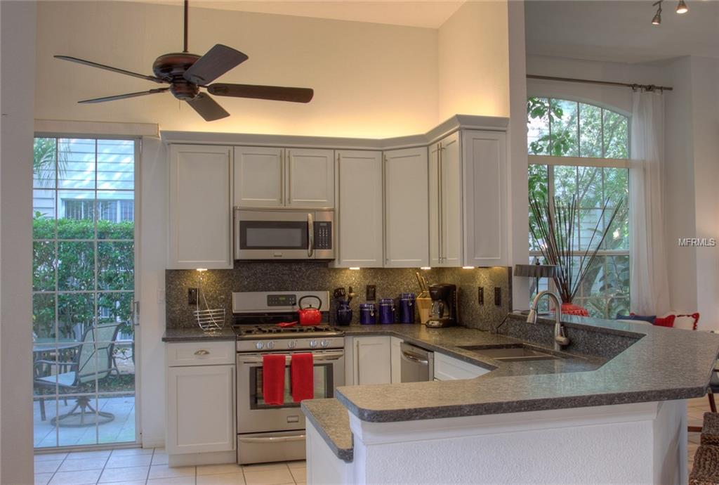 Modern kitchen with white cabinets and granite countertops.