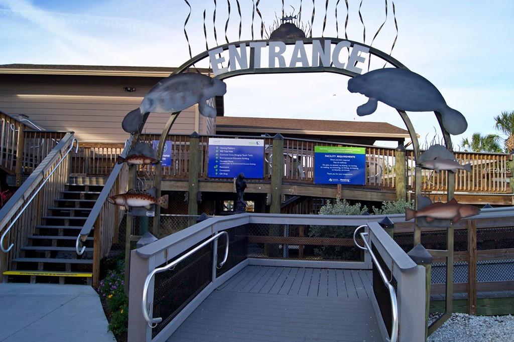 Entrance archway with manatee and fish sculptures.