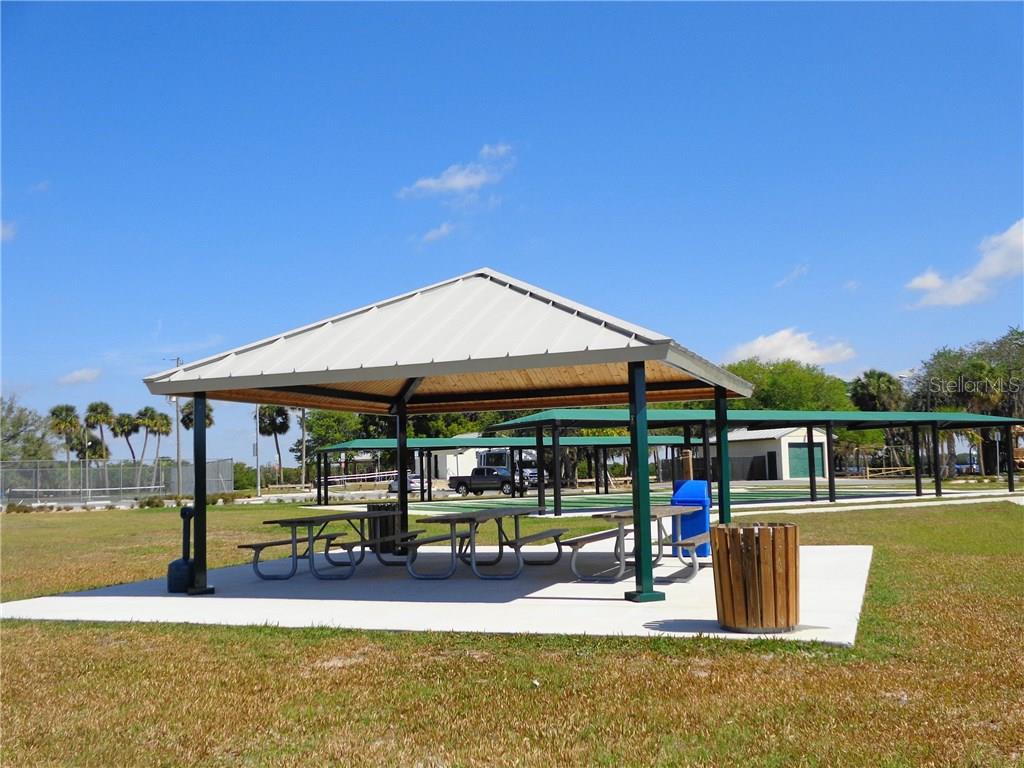 Park pavilion with picnic tables and trash can.