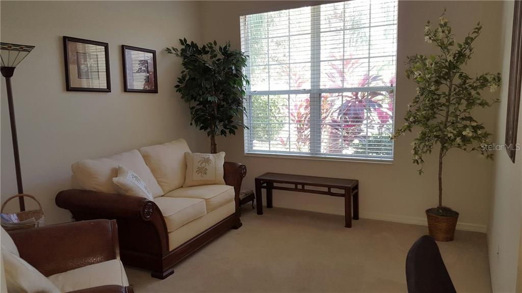 Living room with couch, table, and plants.