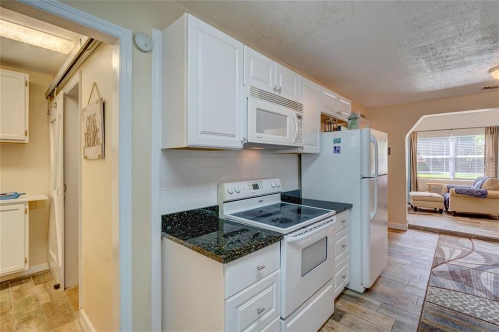 White kitchen with black countertop and oven.